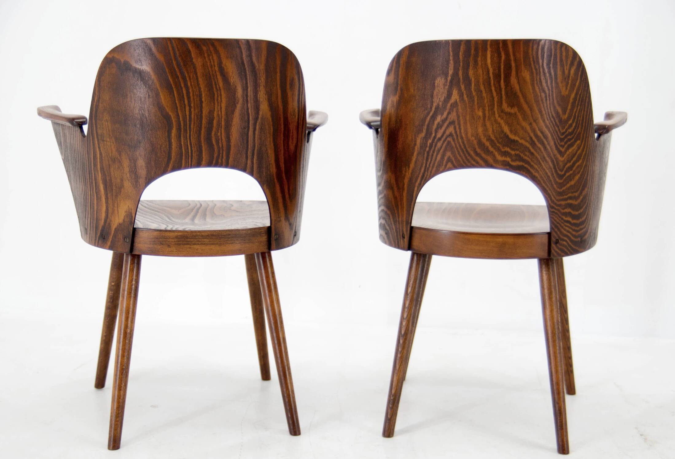 Pair of curved wooden shell armchairs in the style of Oswald Haerdtl.