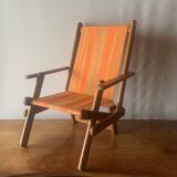 Old foldable beach seat in wood and canvas for children