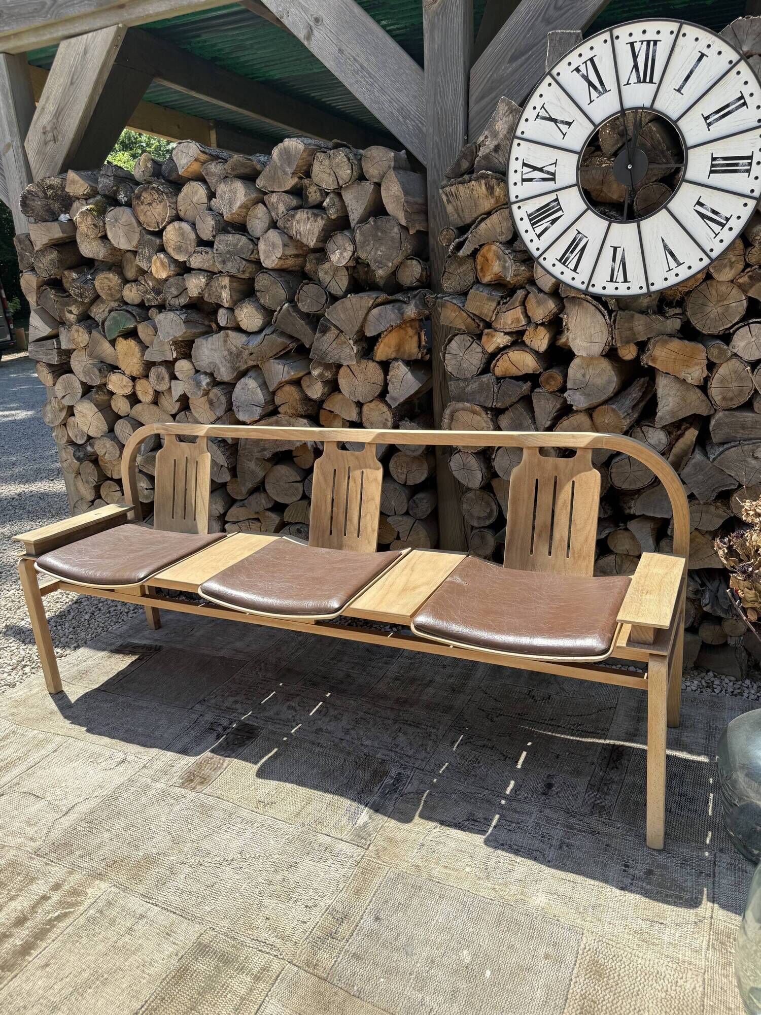 Baumann bench with wooden frame and faux leather seat.