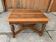 Hungarian carved wooden dining table in brown, circa 1890 — square top, turned legs and carved crossbars.