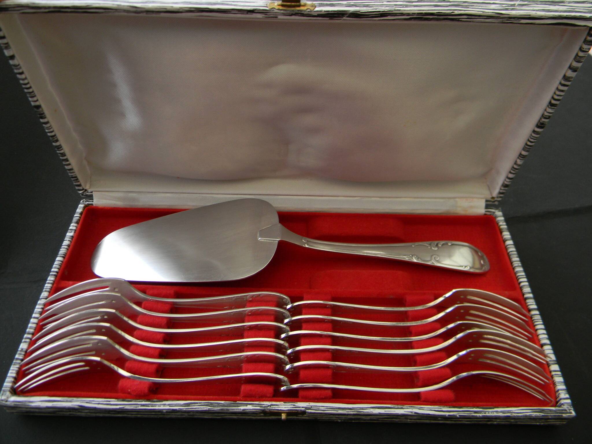 12 cake forks and a silver metal server.