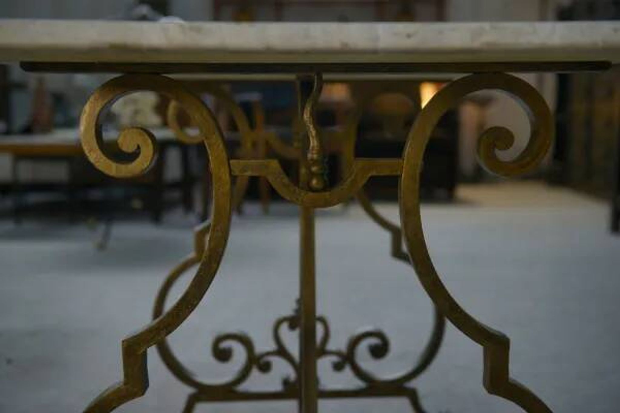 Side table with a gilt wrought iron base attributed to Gilbert Poillerat, with a travertine top, 1940s