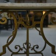 Side table with a gilt wrought iron base attributed to Gilbert Poillerat, with a travertine top, 1940s