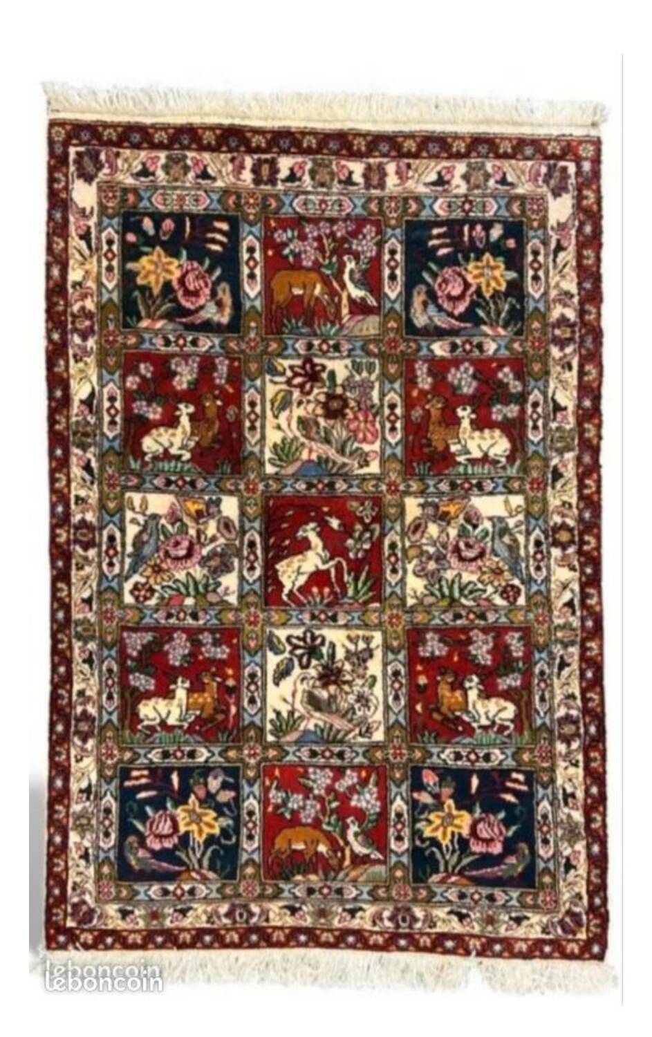 Handmade Persian carpet, featuring animal and plant motifs.