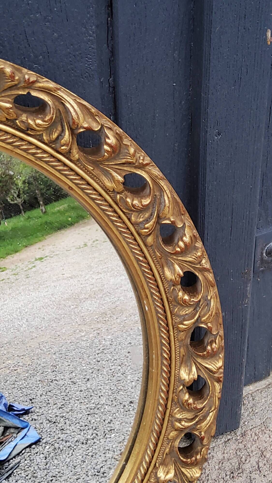 Round neoclassical style mirror in wood and gilded stucco from the 1950s