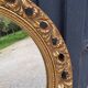 Round neoclassical style mirror in wood and gilded stucco from the 1950s