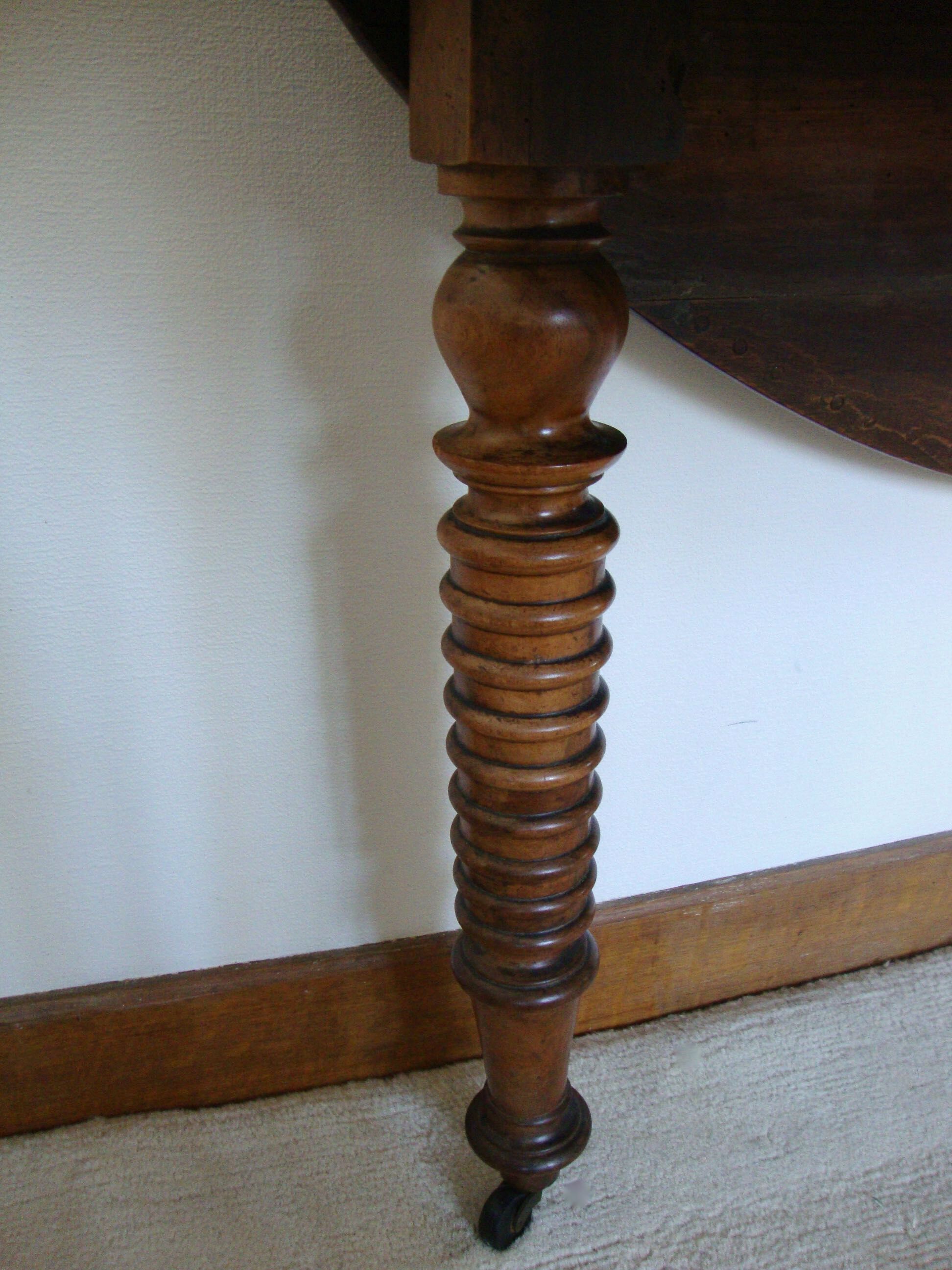 Mid-19th-century walnut round table with shutters, flaps