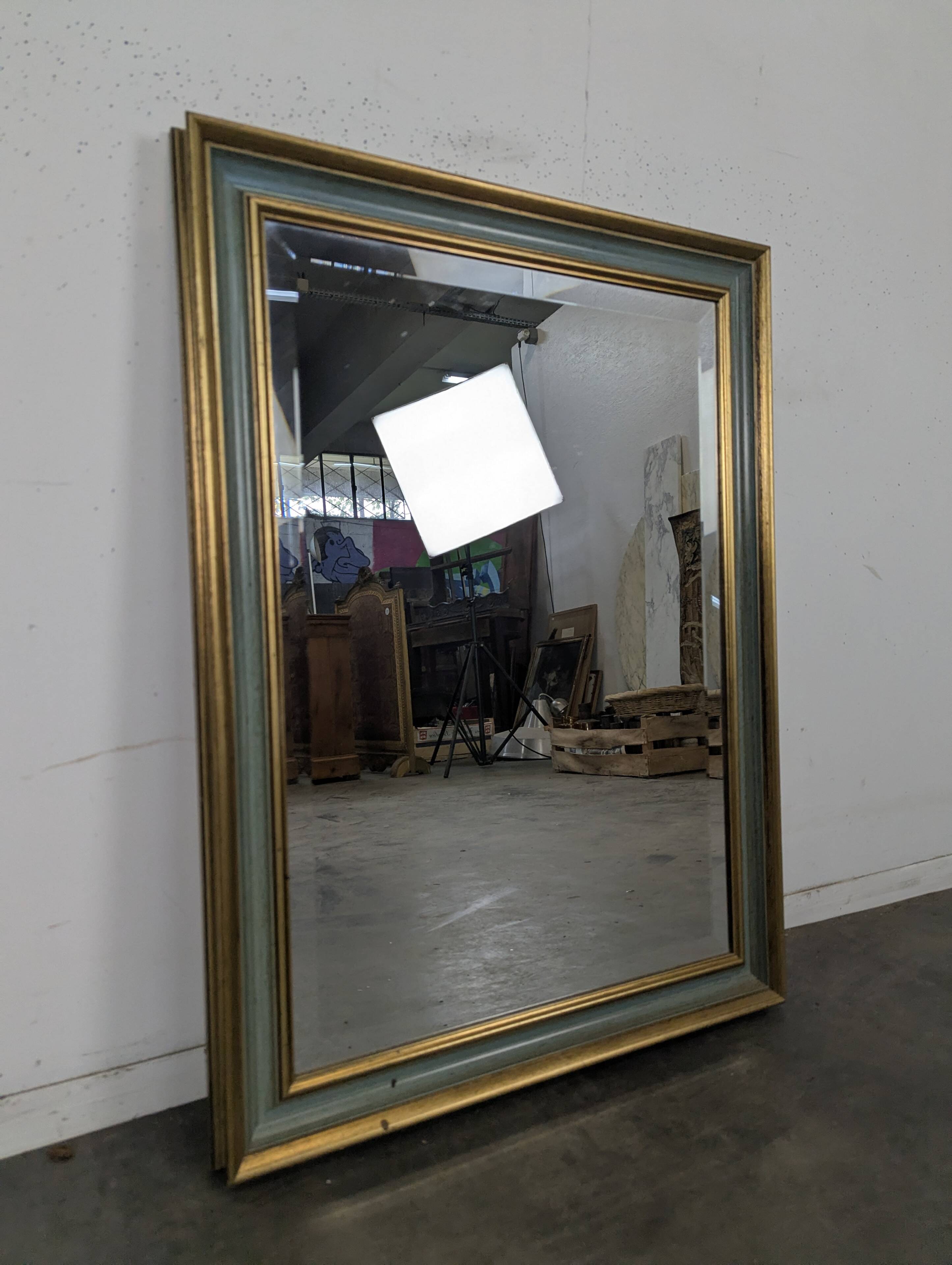 Rectangular mirror with a green and gold lacquered frame.