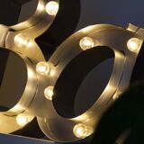 Enseigne lumineuse en lettrage aluminium formant le mot "bar"