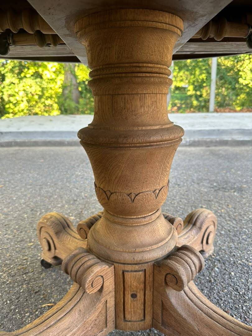 Round dining table with a central pedestal, stripped raw oak, 4 extensions, 19th century.