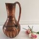 Pitcher-shaped vase in hammered copper