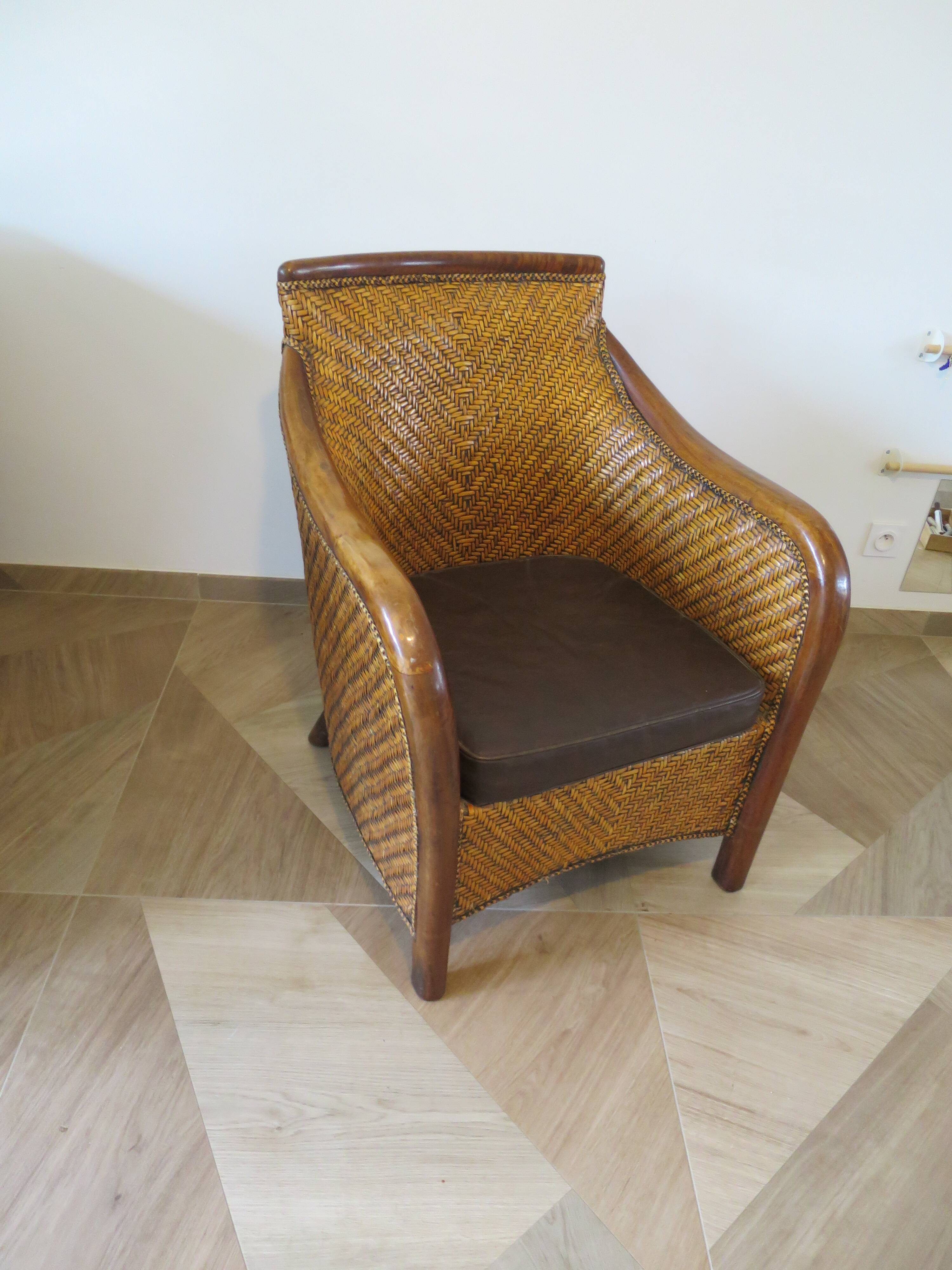 Colonial style armchair in woven rattan and exotic wood
