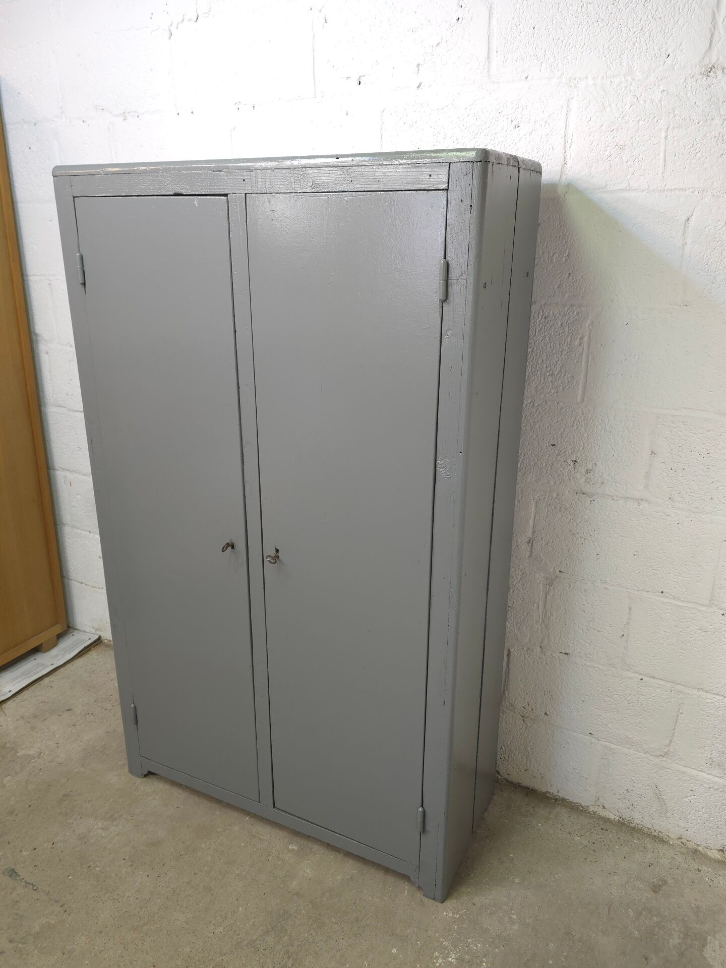 Curved wardrobe workshop locker made of wood repainted in grey.