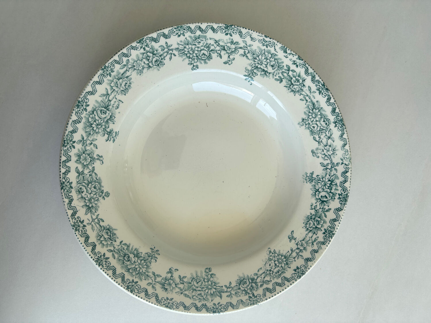 A deep plate in blue and green ironstone, antique French earthenware.