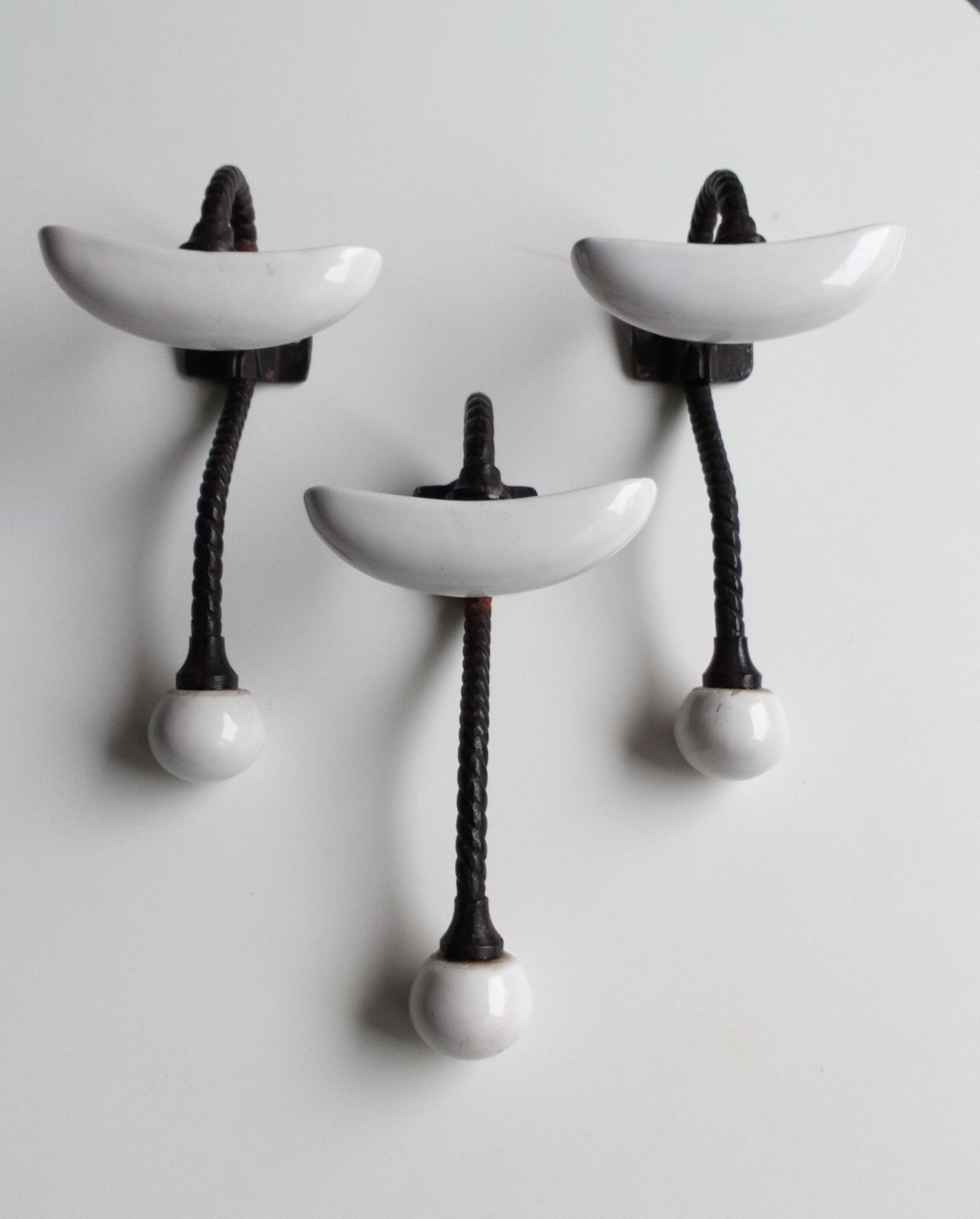 Trois patères doubles en fer forgé et porcelaine