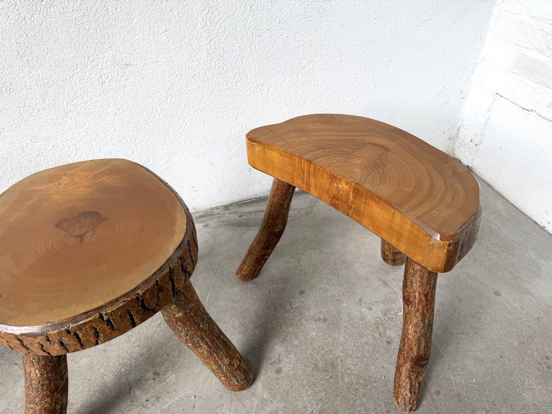 Set of three rustic solid wood tripod stools.