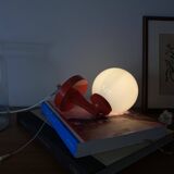Red plastic wall light with a white opaline glass globe.