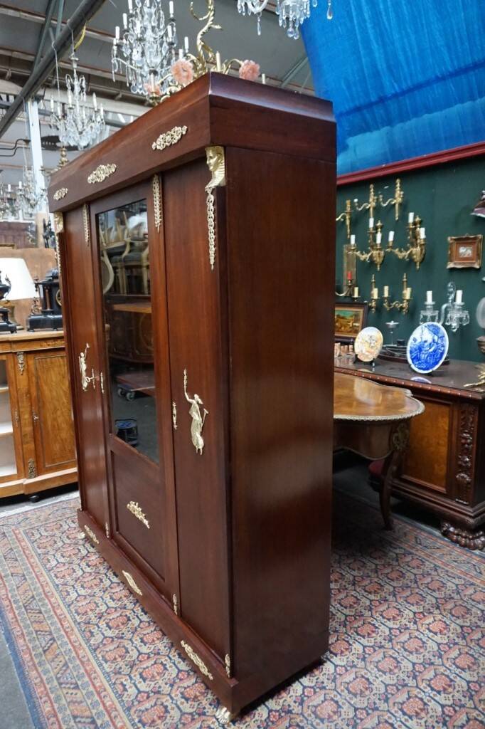 Empire style mahogany display bookcase with gilt bronze decoration and three doors.