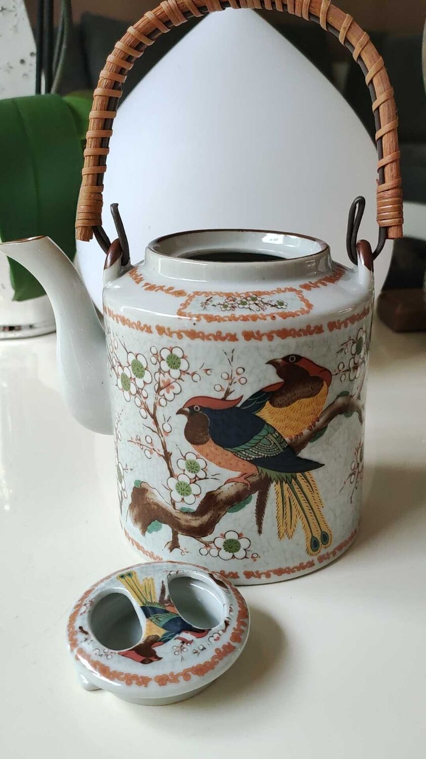 Japanese ceramic teapot. bird/paradise motifs/cherry trees. bamboo/rattan braided handle