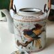 Japanese ceramic teapot. bird/paradise motifs/cherry trees. bamboo/rattan braided handle