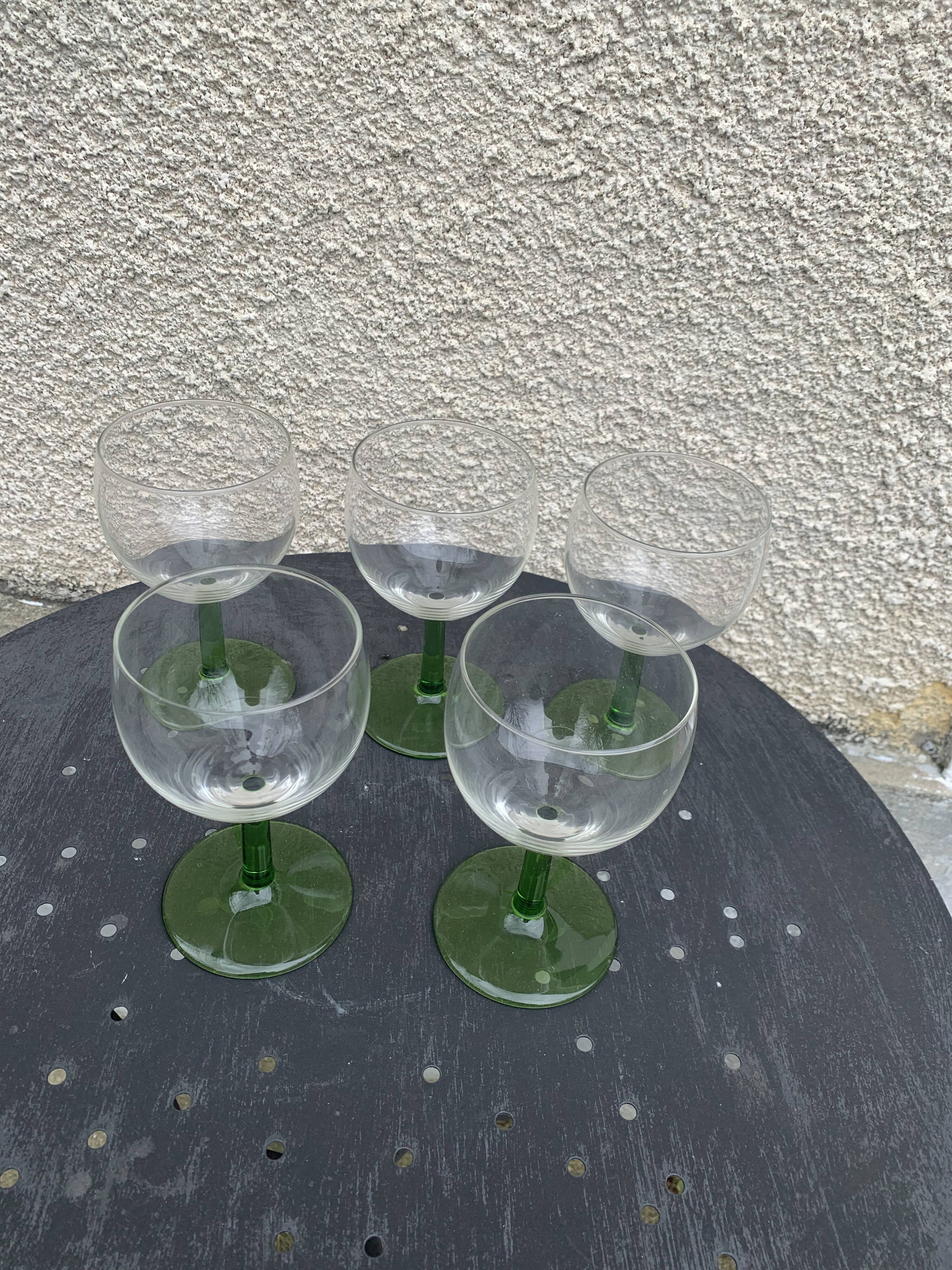 5 transparent glass glasses and green glass vase go