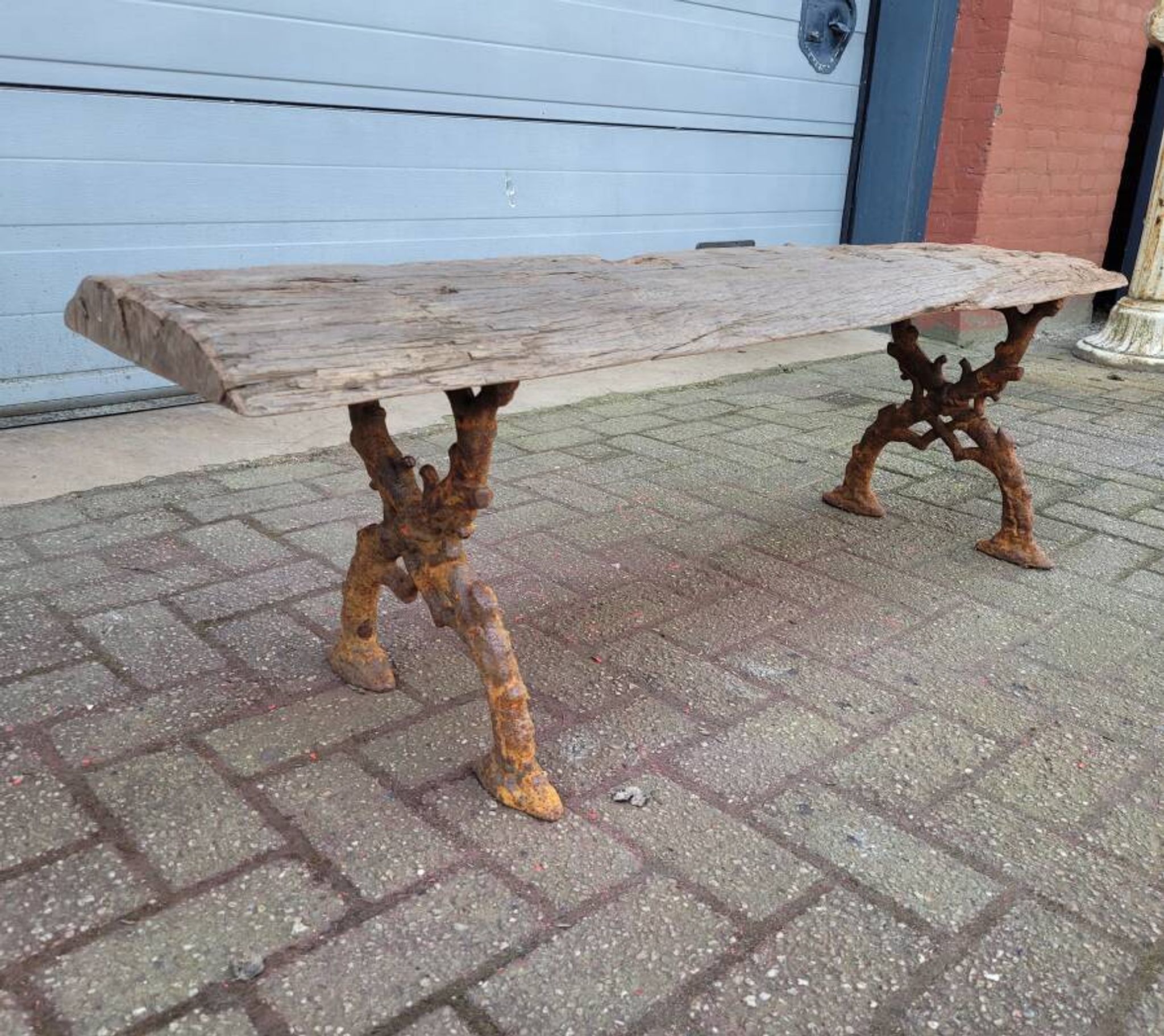 French country style cast iron bench with old rustic wooden plank