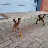 French country style cast iron bench with old rustic wooden plank