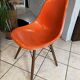 A vintage 70s Eames Herman Miller DSW Fiber Red Orange Dowel Walnut Chair