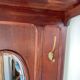 Antique wooden coat rack with mirror and shelf.