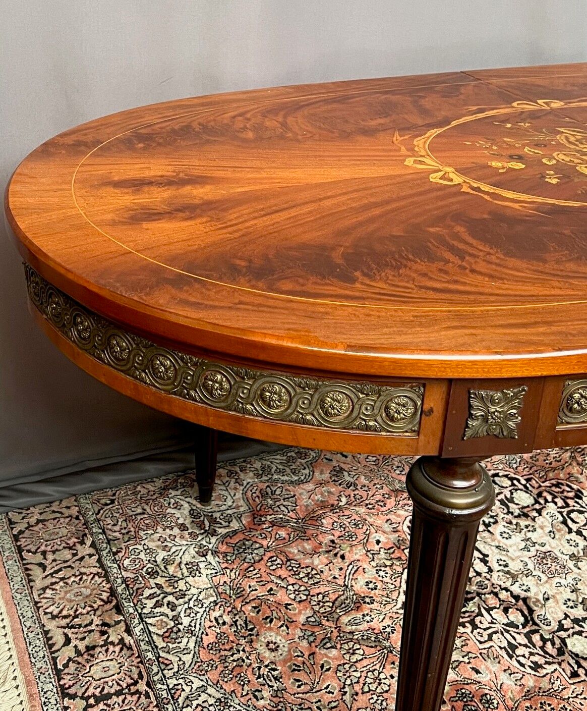 Louis XVI style oval dining table with rosewood marquetry extension mounted in bronze