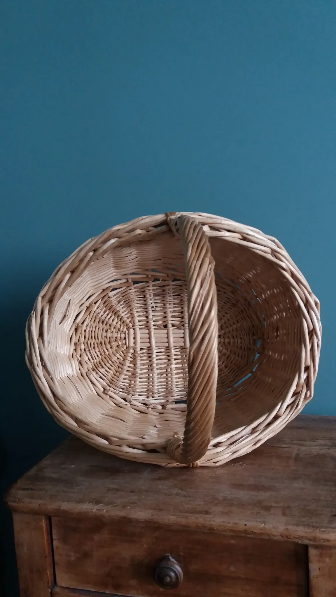 Handcrafted wicker basket with a handle.