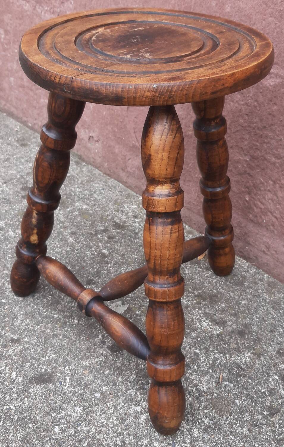 Low wooden tripod stool.