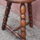 Low wooden tripod stool.