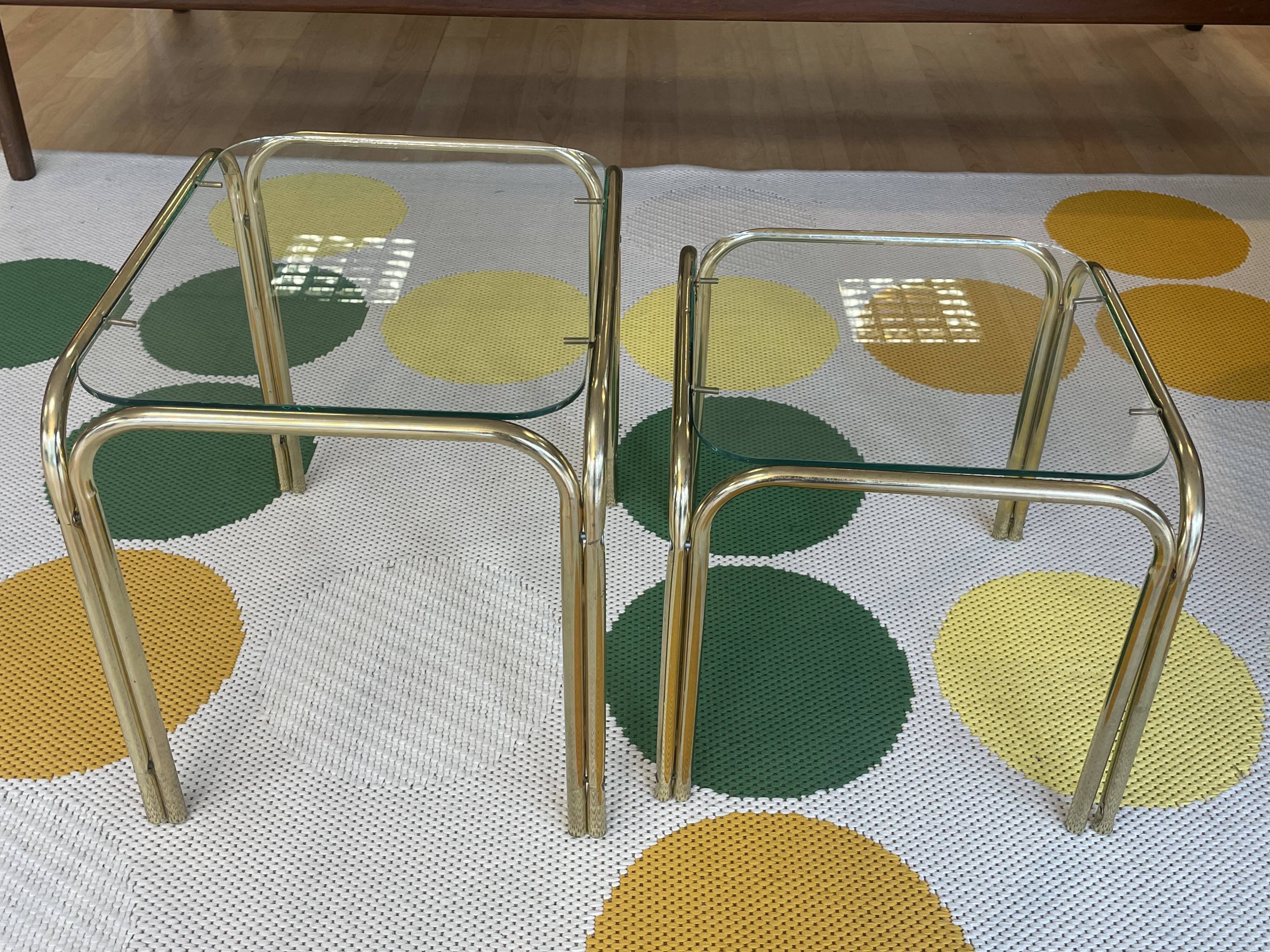 Pair of small nesting coffee tables in gold tubular metal & transparent glass tops