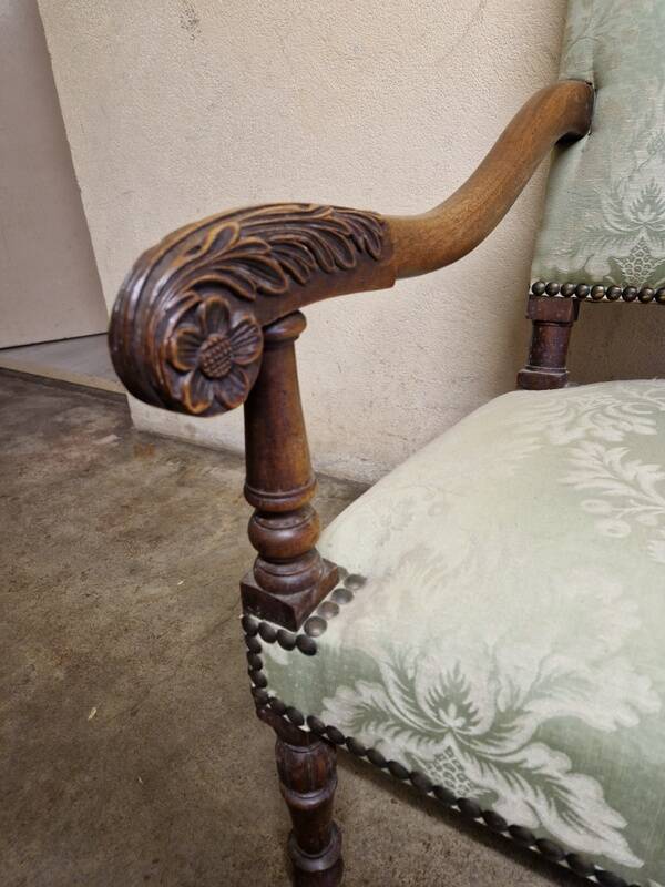 Antique Louis XIV style armchair in moulded wood and damask-style fabric.