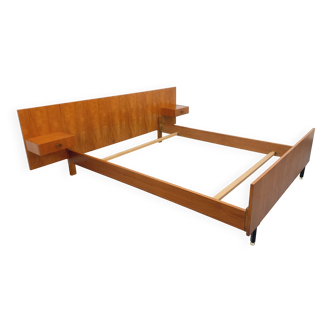 Double bed vintage modernist in teak and black metal from the 1960s with bedside tables.