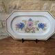 Rectangular earthenware dish with a glazed finish, decorated with a bouquet of flowers.