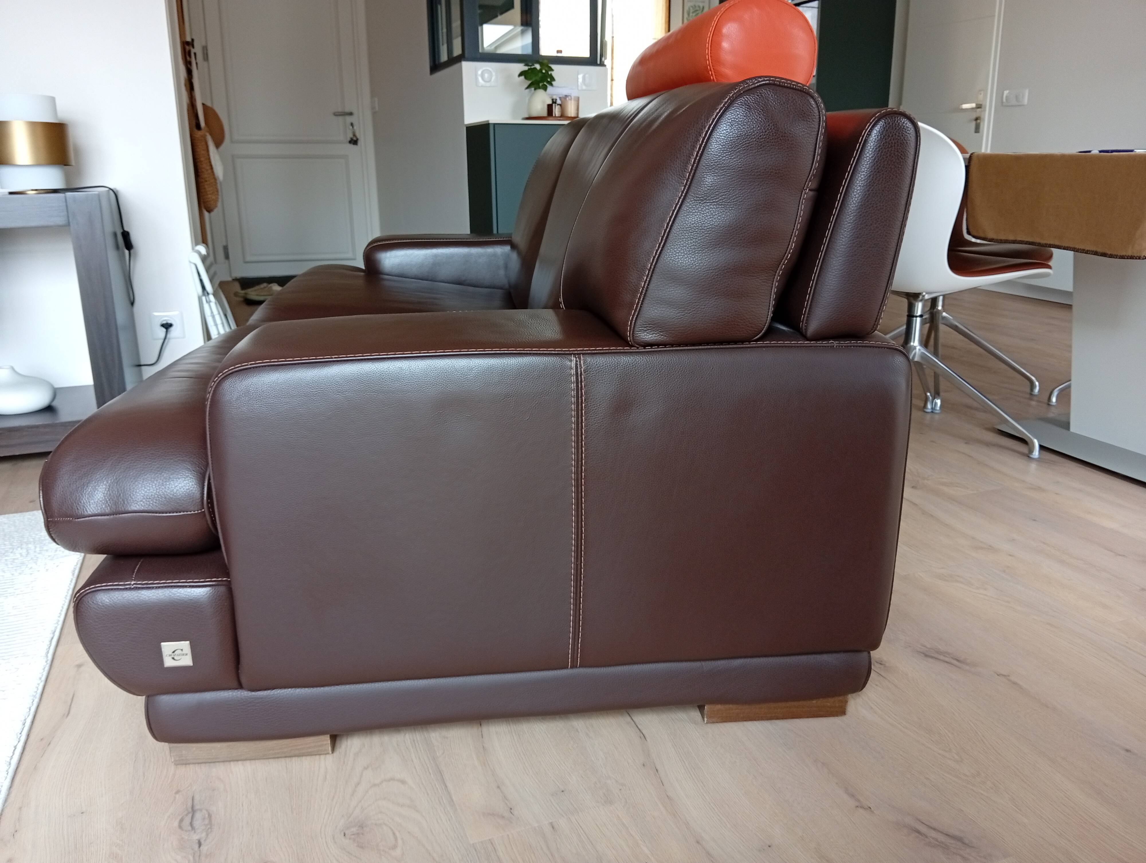 Two brown leather Crozatier two-and-a-half-seater sofas.