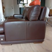 Two brown leather Crozatier two-and-a-half-seater sofas.