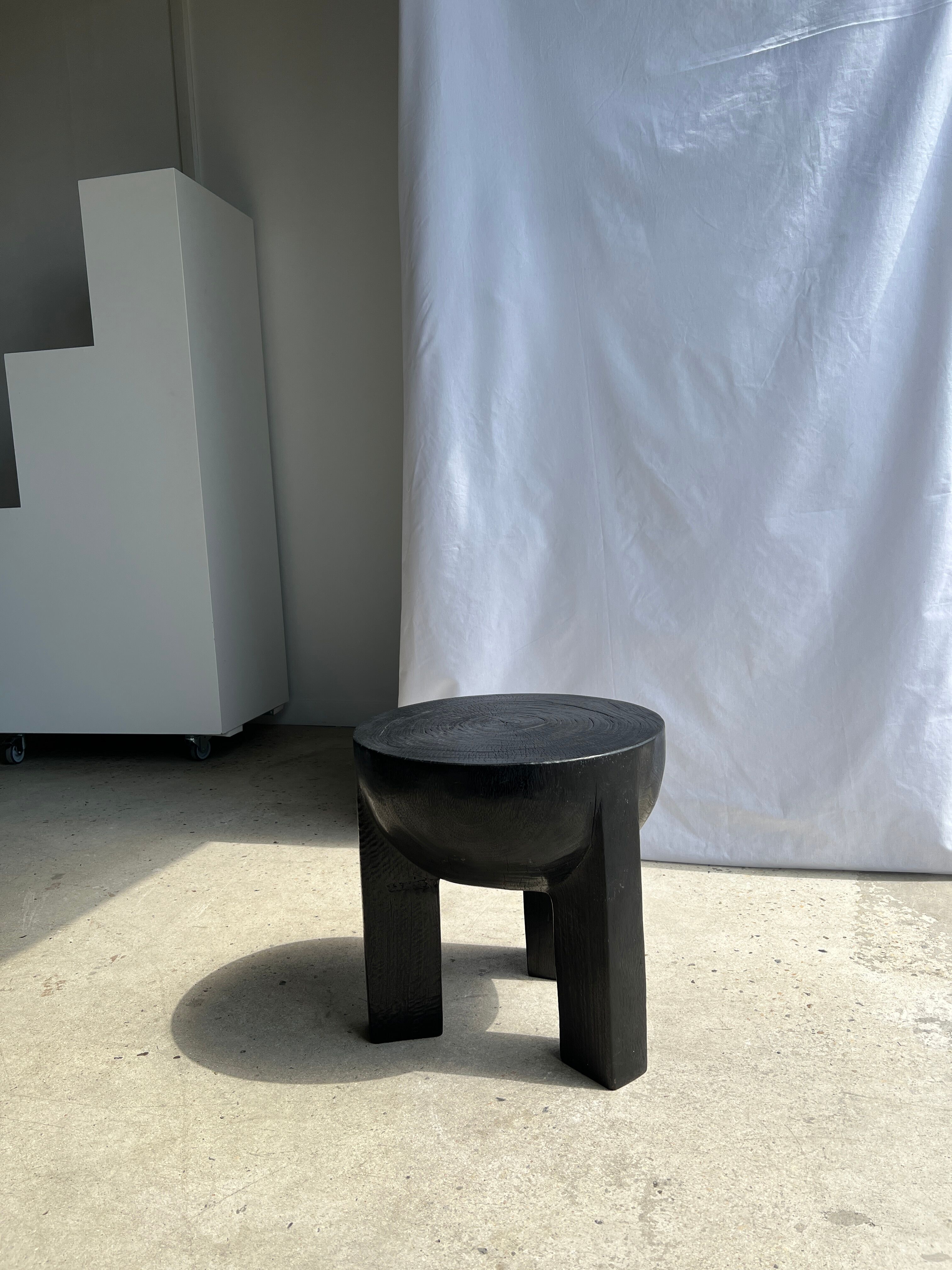Black mango wood tripod side table with a semi-spherical top, height: 45 cm, diameter: 44 cm.