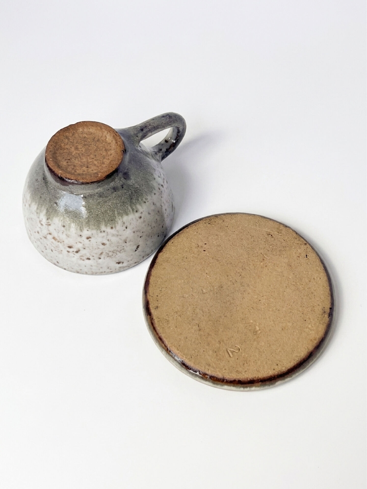 Handcrafted stoneware cup and its saucer – Speckled glaze