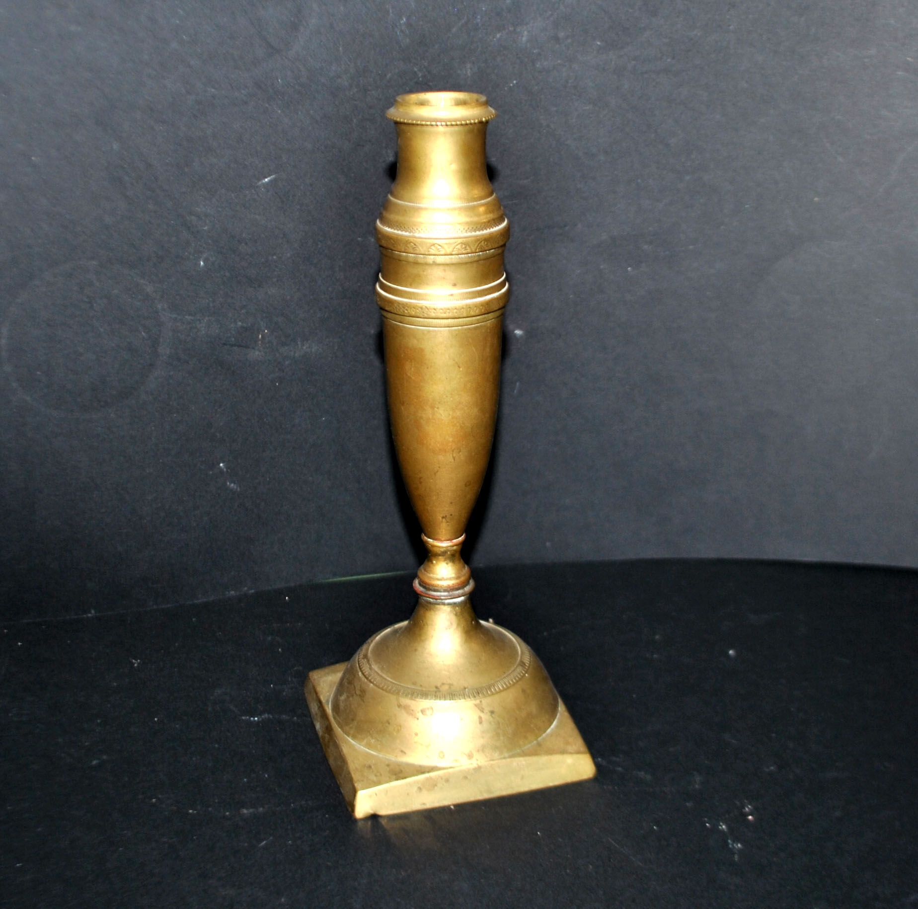 Antique baluster candlestick in bronze with hand-chiseled design.