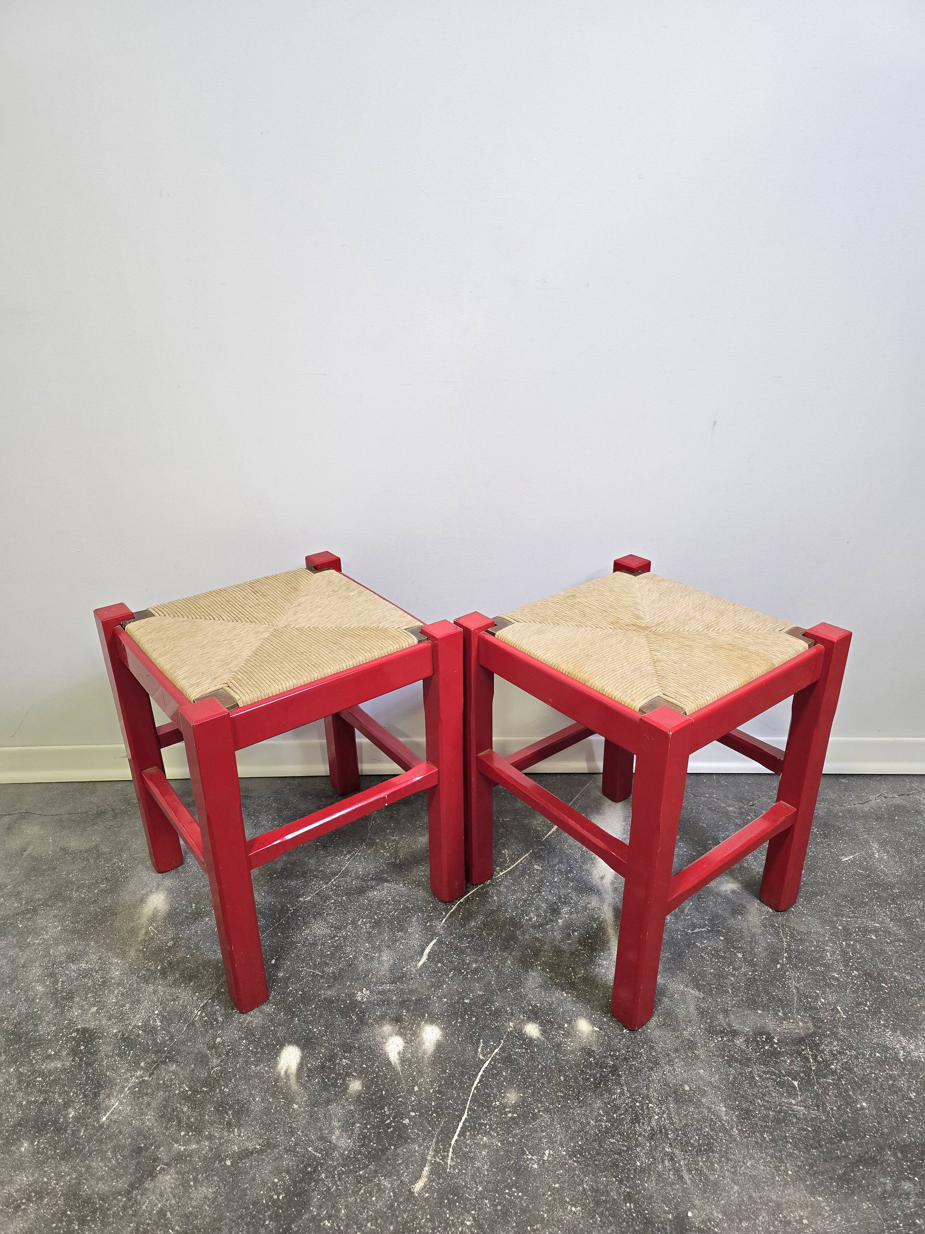 Red wooden stool with woven rush seat.