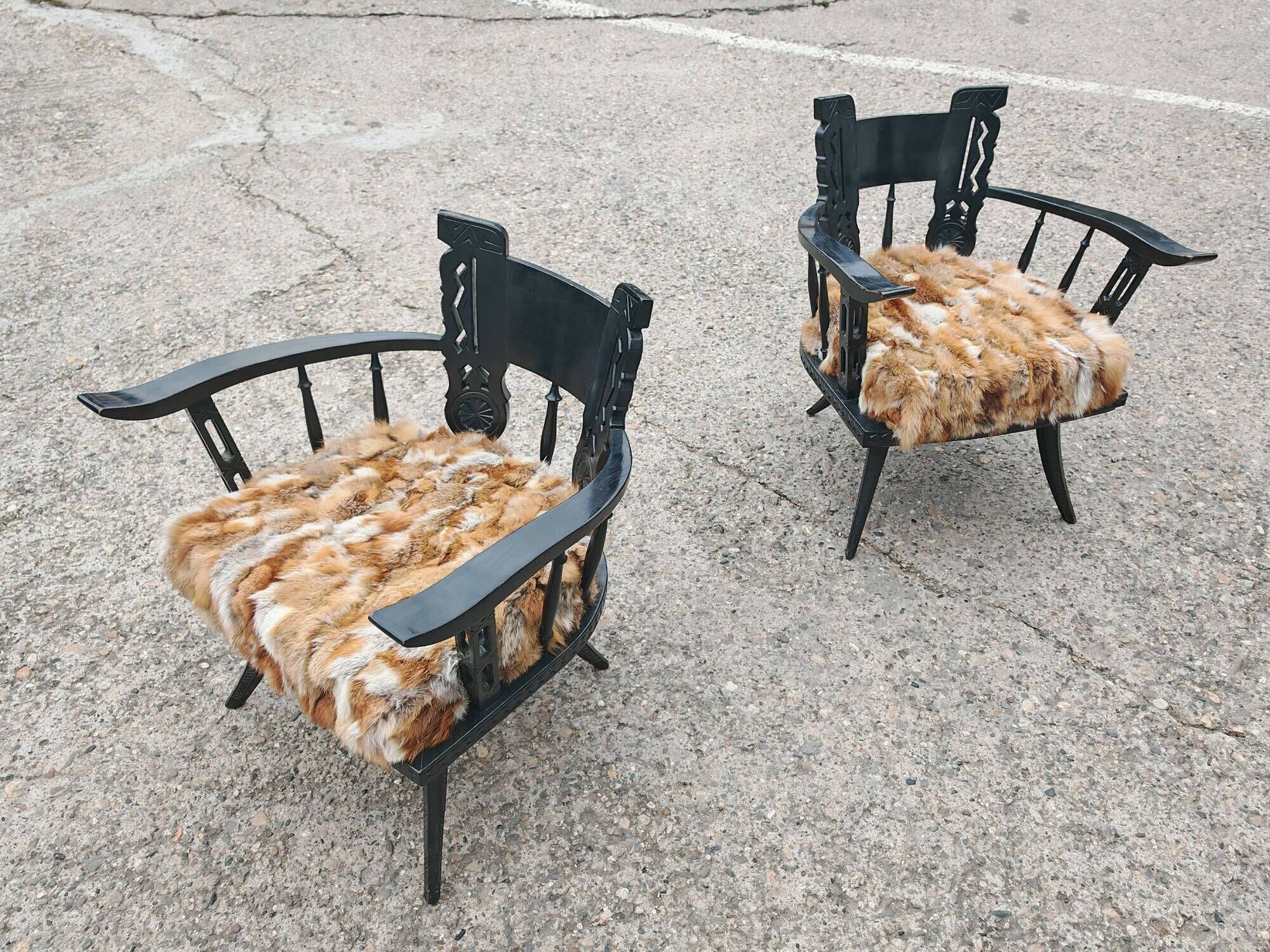 Pair of hand-carved armchairs in black lacquer and fur, 1920s.