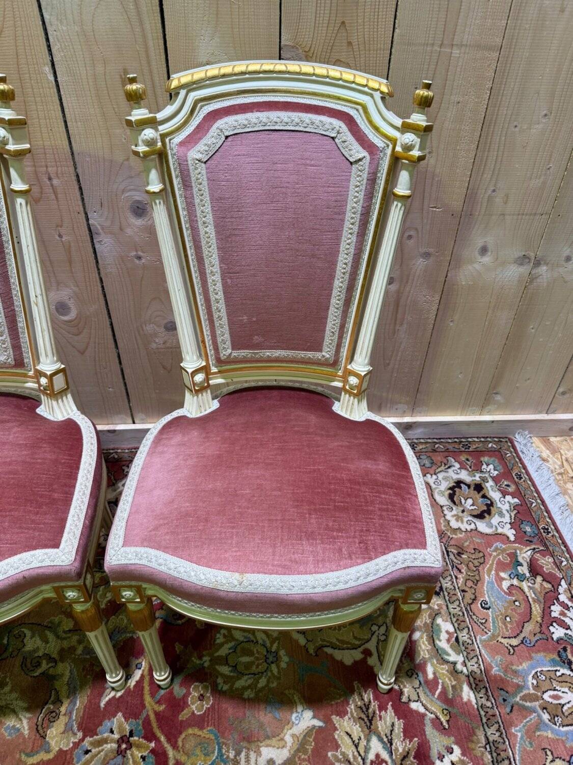 Louis XVI dining room table set with painted wood, gold accents, and pink velvet.