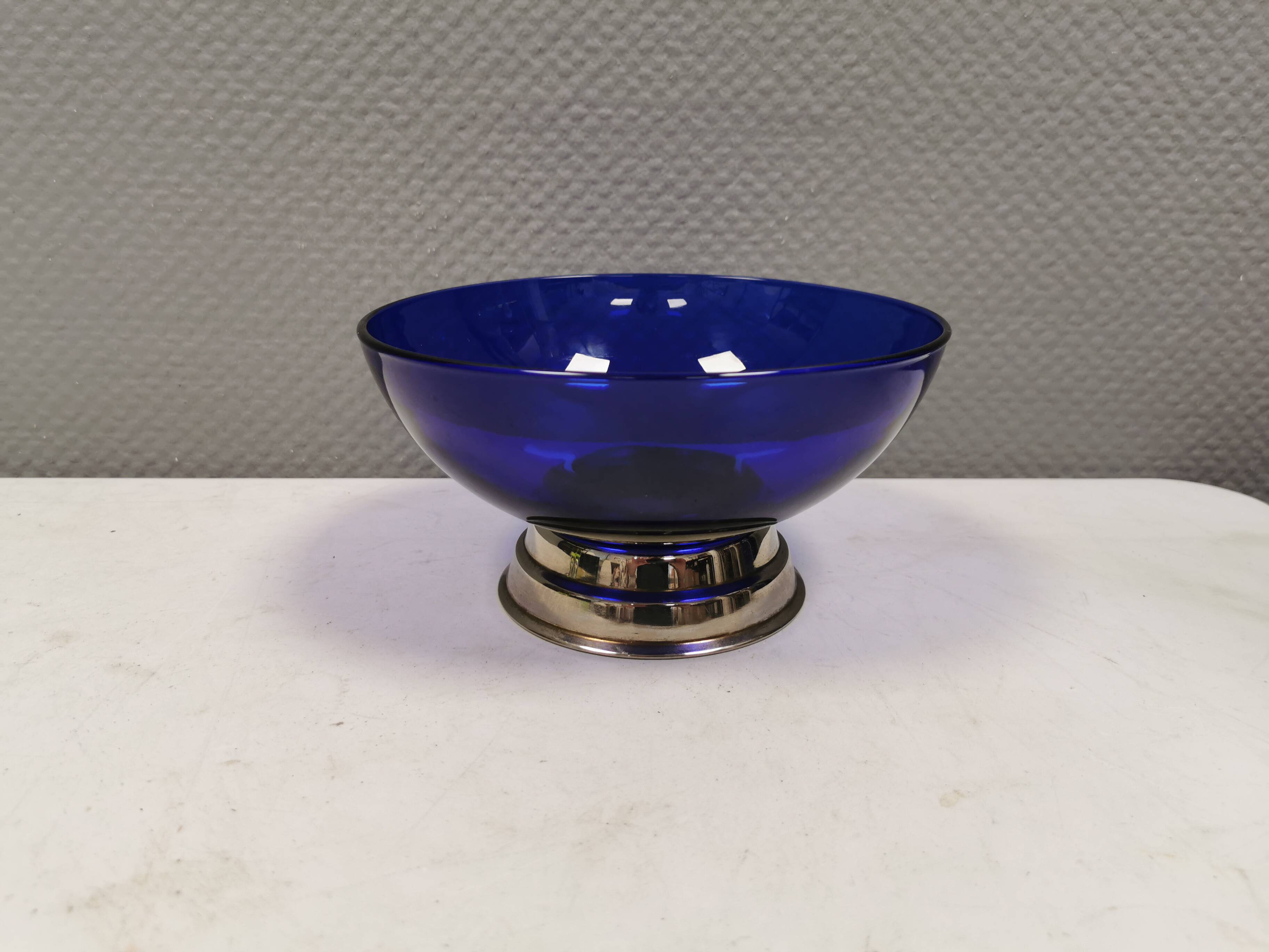Beautiful blue glass bowl mounted on silver colored base (Original).