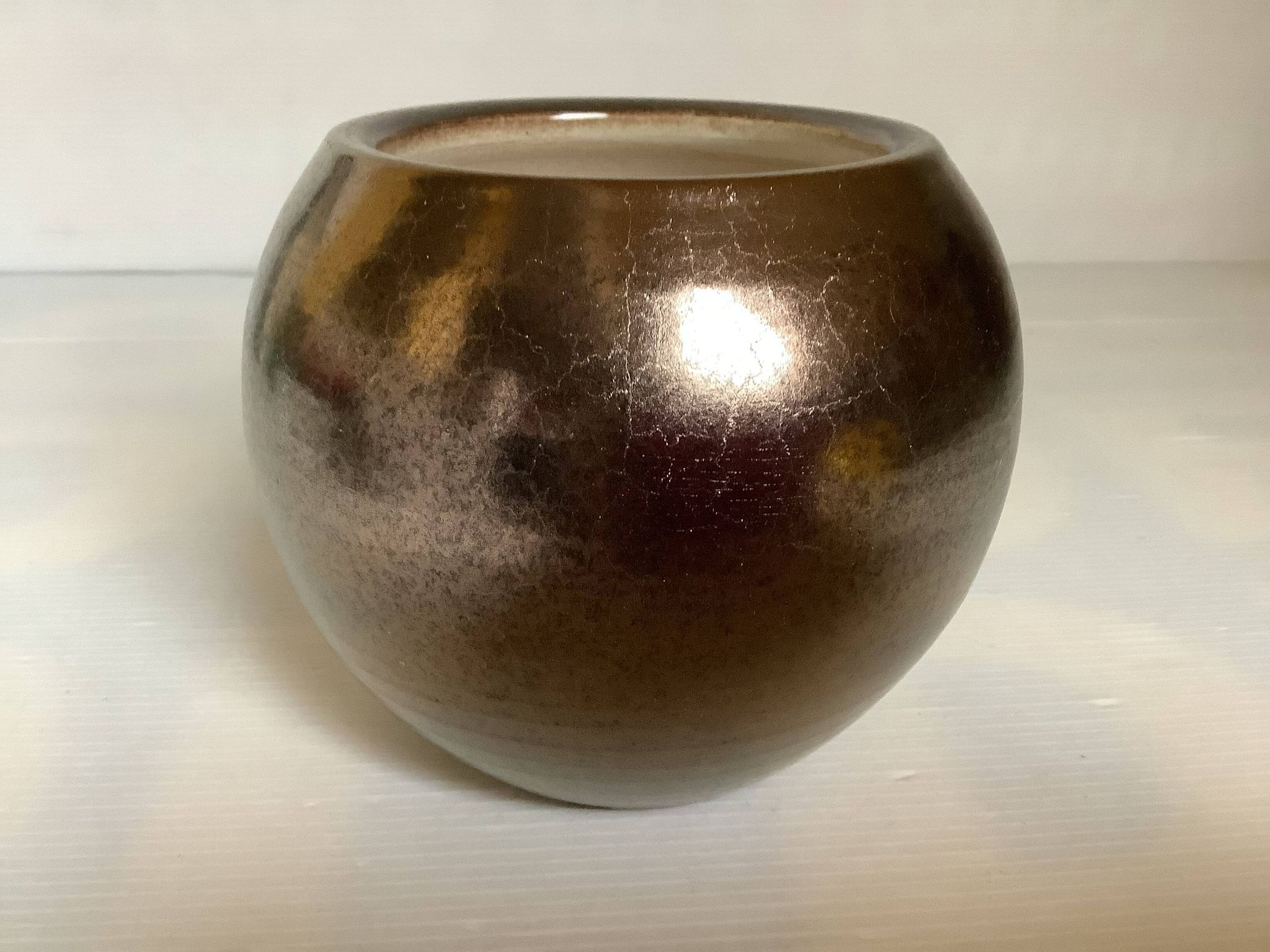 Small round vase, cracked golden ceramic.
