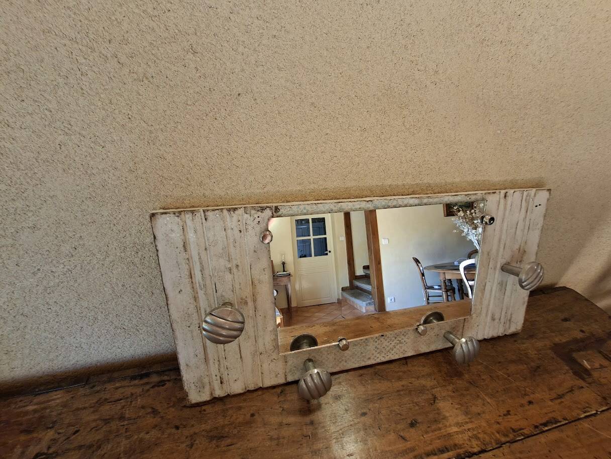 Wall-mounted coat rack with a patinated mirror