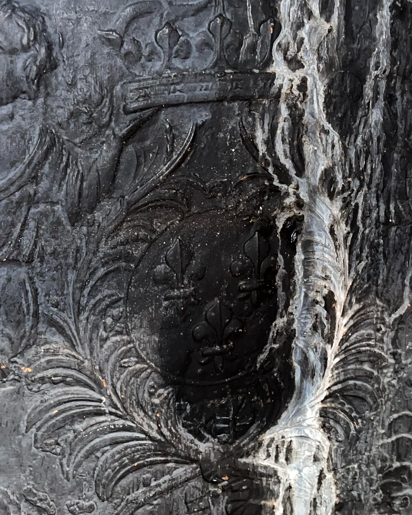 huge old fireplace plate has decoration of angels, crown and fleurs-de-lis