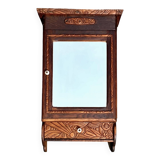 Old carved wooden medicine cabinet with beveled mirror